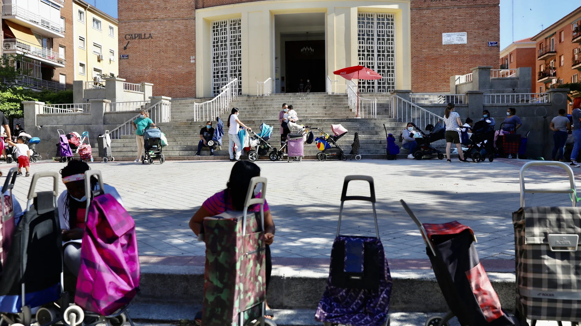 Colas del hambre con carritos de bebés junto a la parroquia de San Amaro para recibir alimentos.