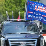 Un simpatizante de Donald Trump enarbola banderas a favor del expresidente en su automóvil