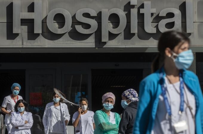 Medical staff and nurses wearing face masks to prevent the spread of coronavirus gather during a protest demanding an improvement in wages and labor conditions at La Paz hospital in Madrid, Spain, Monday, Oct. 5, 2020. Madrid has been the source of Europe's most worrying surge of infections in the ongoing second wave of the pandemic.