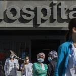 Medical staff and nurses wearing face masks to prevent the spread of coronavirus gather during a protest demanding an improvement in wages and labor conditions at La Paz hospital in Madrid, Spain, Monday, Oct. 5, 2020. Madrid has been the source of Europe's most worrying surge of infections in the ongoing second wave of the pandemic.