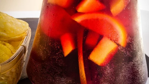 Una jarra de sangría acompañada de un aperitivo