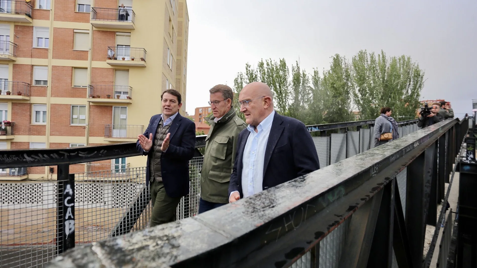 Carnero y Mañueco conversan con Feijóo mientras pasean por un puente sobre las vías del tren en Valladolid