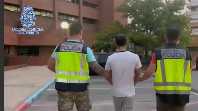 Agentes de Policía conducen a uno d elos detenidos