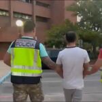 Agentes de Policía conducen a uno d elos detenidos