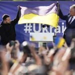 Ukraine's President Volodymyr Zelenskyy, second left, and Lithuania's President Gitanas Nauseda, second right, hold up a Ukrainian flag as they address the crowd during an event on the sidelines of a NATO summit in Vilnius, Lithuania, Tuesday, July 11, 2023. Ukrainian President Volodymyr Zelenskyy on Tuesday blasted as "absurd" the absence of a timetable for his country's membership in NATO, injecting harsh criticism into a gathering of the alliance's leaders that was intended to showcase solidarity in the face of Russian aggression. (AP Photo/Pavel Golovkin)
