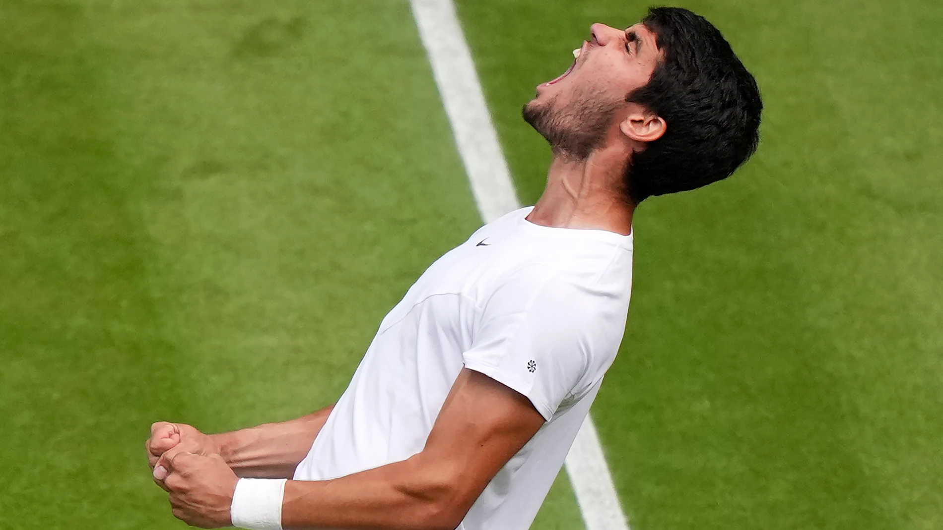 Spain's Carlos Alcaraz reacts after beating Denmark's Holger Rune to win their men's singles match on day ten of the Wimbledon tennis championships in London, Wednesday, July 12, 2023. (AP Photo/Alberto Pezzali)