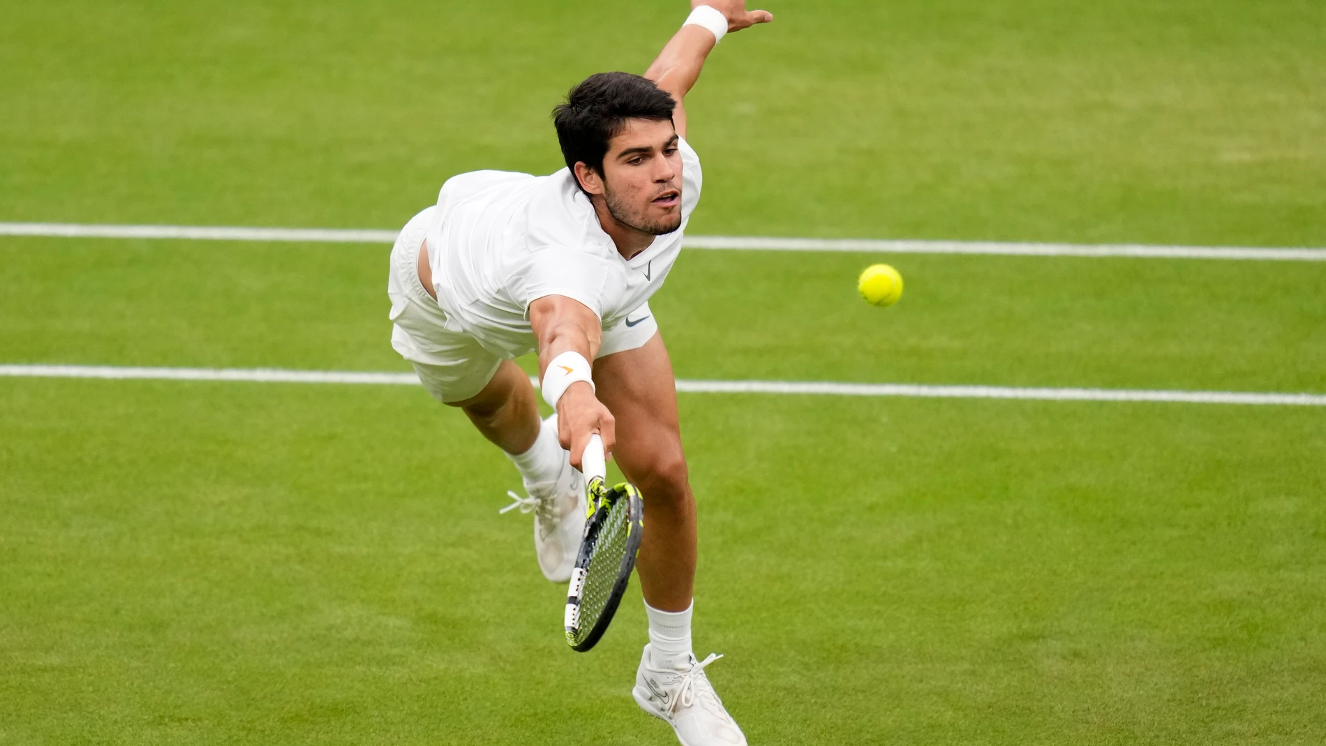 Spain's Carlos Alcaraz returns to Russia's Daniil Medvedev in a men's singles semifinal match on day twelve of the Wimbledon tennis championships in London, Friday, July 14, 2023. (AP Photo/Kirsty Wigglesworth)