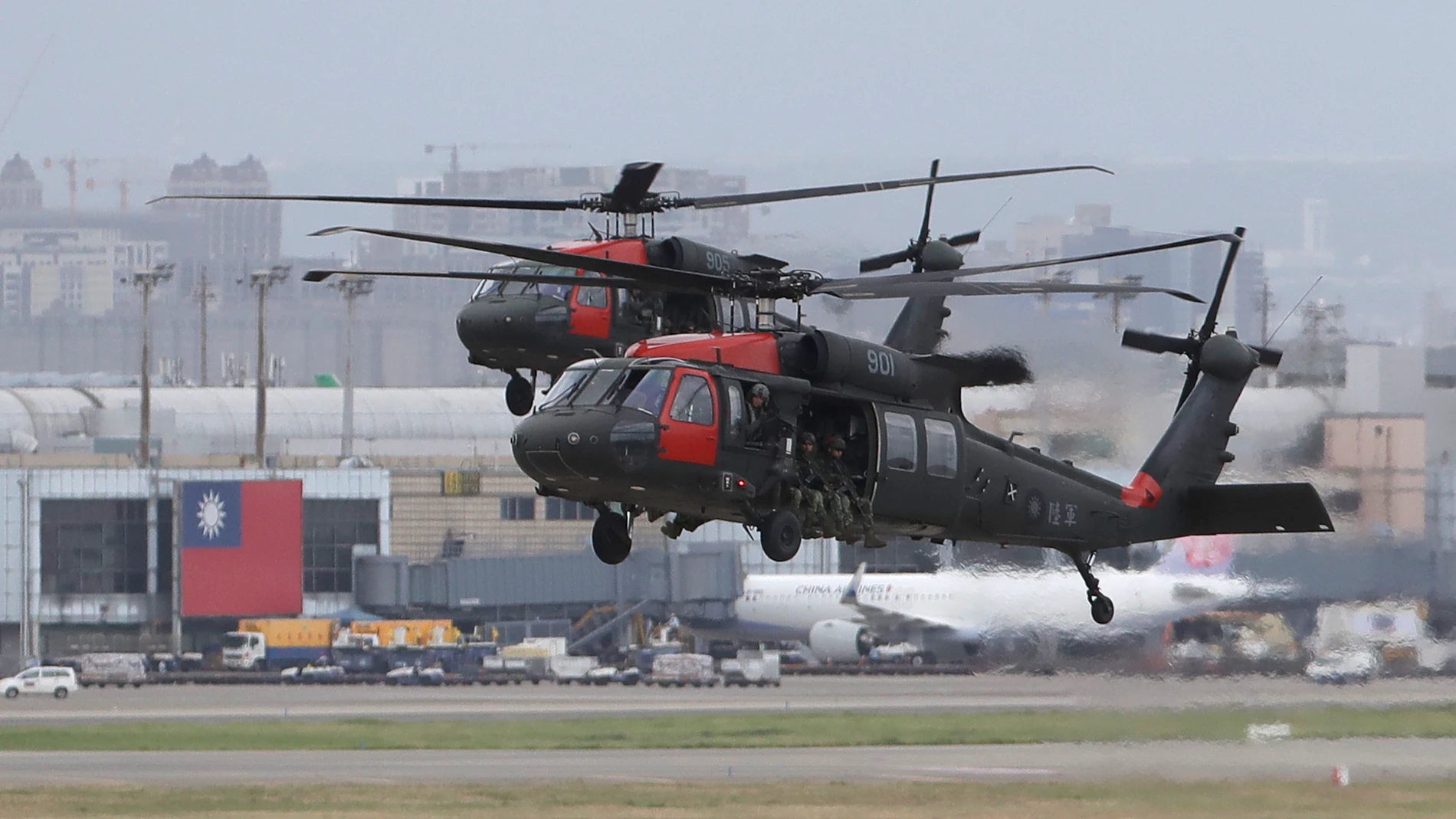 Two Sikorsky UH-60 "Black Hawk" helicopters approach during the annual Han Kuang military exercises that simulates an attack on an airfield at Taoyuan International Airport in Taoyuan, northern Taiwan, Wednesday, July 26, 2023. Taiwan military mobilized for routine defense exercises from July 24-28. (AP Photo/ Chiang Ying-ying)