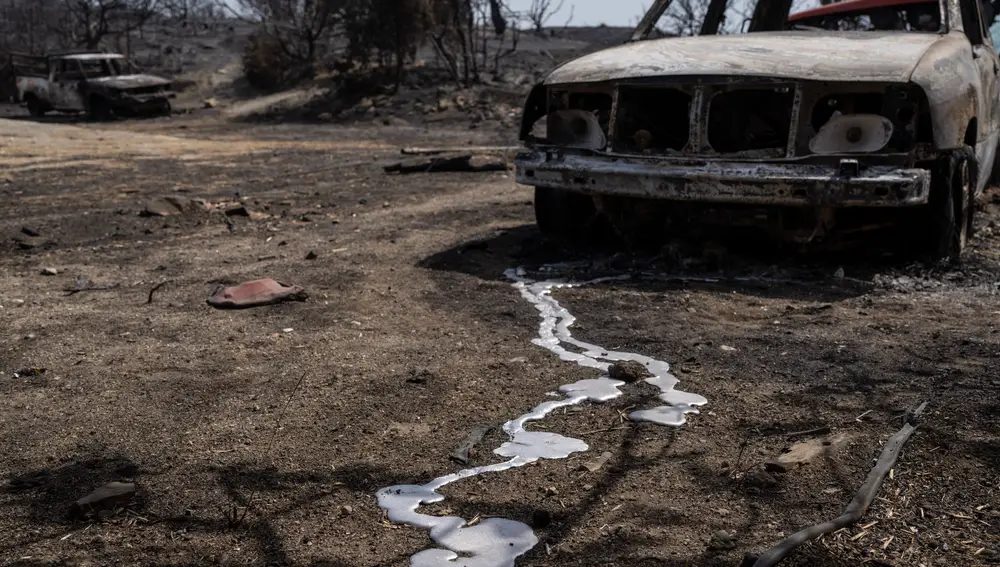 Un coche quemado después de un incendio forestal cerca de la aldea de Gennadi, en la isla del mar Egeo de Rodas, sureste de Grecia, el jueves 27 de julio de 2023