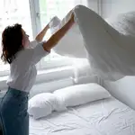 Una mujer hace la cama