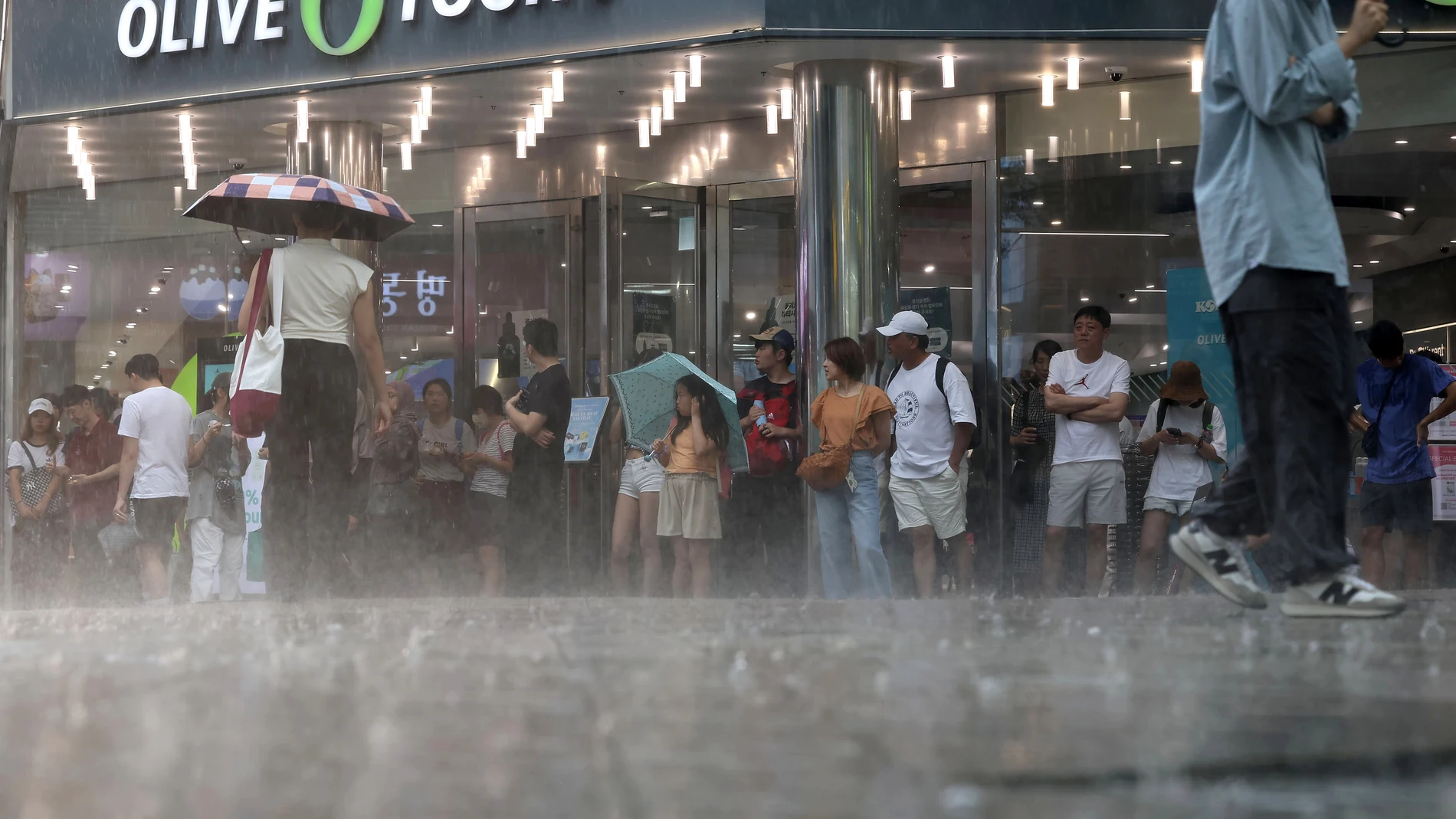 Seoul (Korea, Republic Of), 31/07/2023.- Foreign tourists are caught in a sudden rain shower on Myeongdong Street in Seoul, South Korea, 31 July 2023, amid a heat wave alert. (Corea del Sur, Seúl) EFE/EPA/YONHAP SOUTH KOREA OUT 