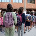 NIñas con mochilas en la entrada de un colegio