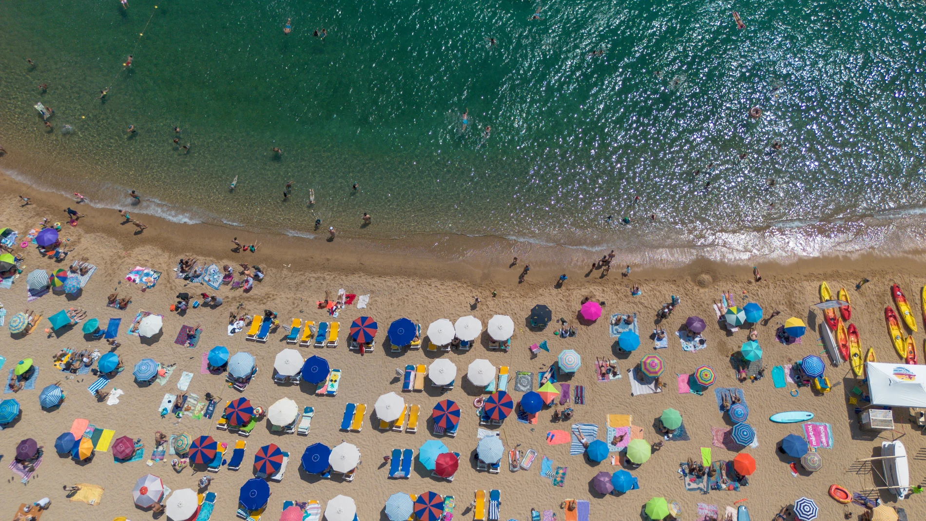 Numerosas personas disfrutan de un día de playa en la Costa Brava, a 30 de julio de 2023, en Tossa de Mar, Girona, Cataluña (España). Las playas españolas se llenan de turistas para paliar el calor. De acuerdo con la información de la Agencia Estatal de Meteorología, los veranos en España se han ido calentando desde los años 80, con olas de calor cada vez más comunes e intensas. Los veranos son cada vez más largos, durando cinco semanas más y aumentando a un ritmo de nueve días por década. ...