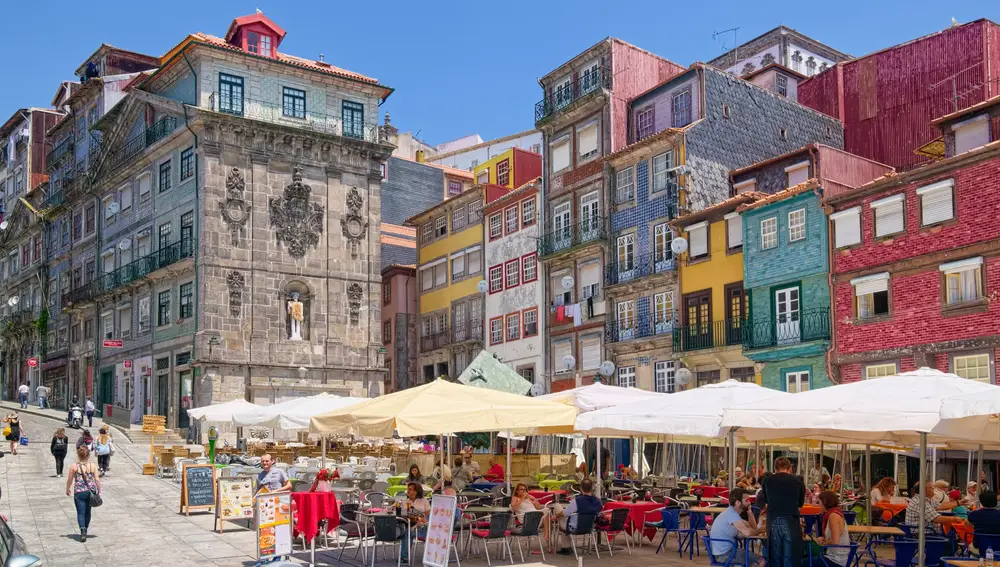 Casas coloridas y cafés al aire libre en la histórica Plaza Ribeira de Oporto.