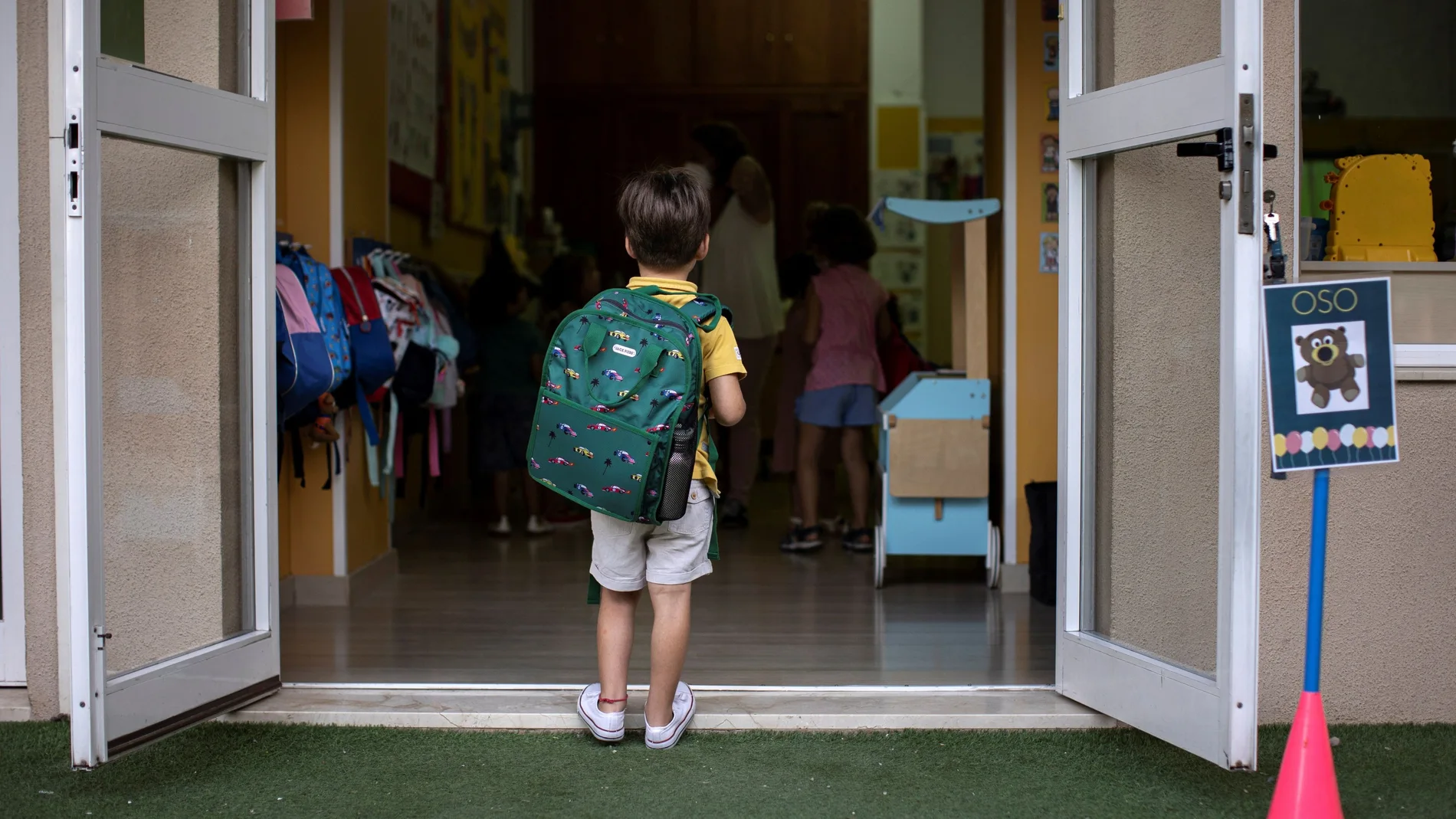 Niño con mochila en la puerta del colegio