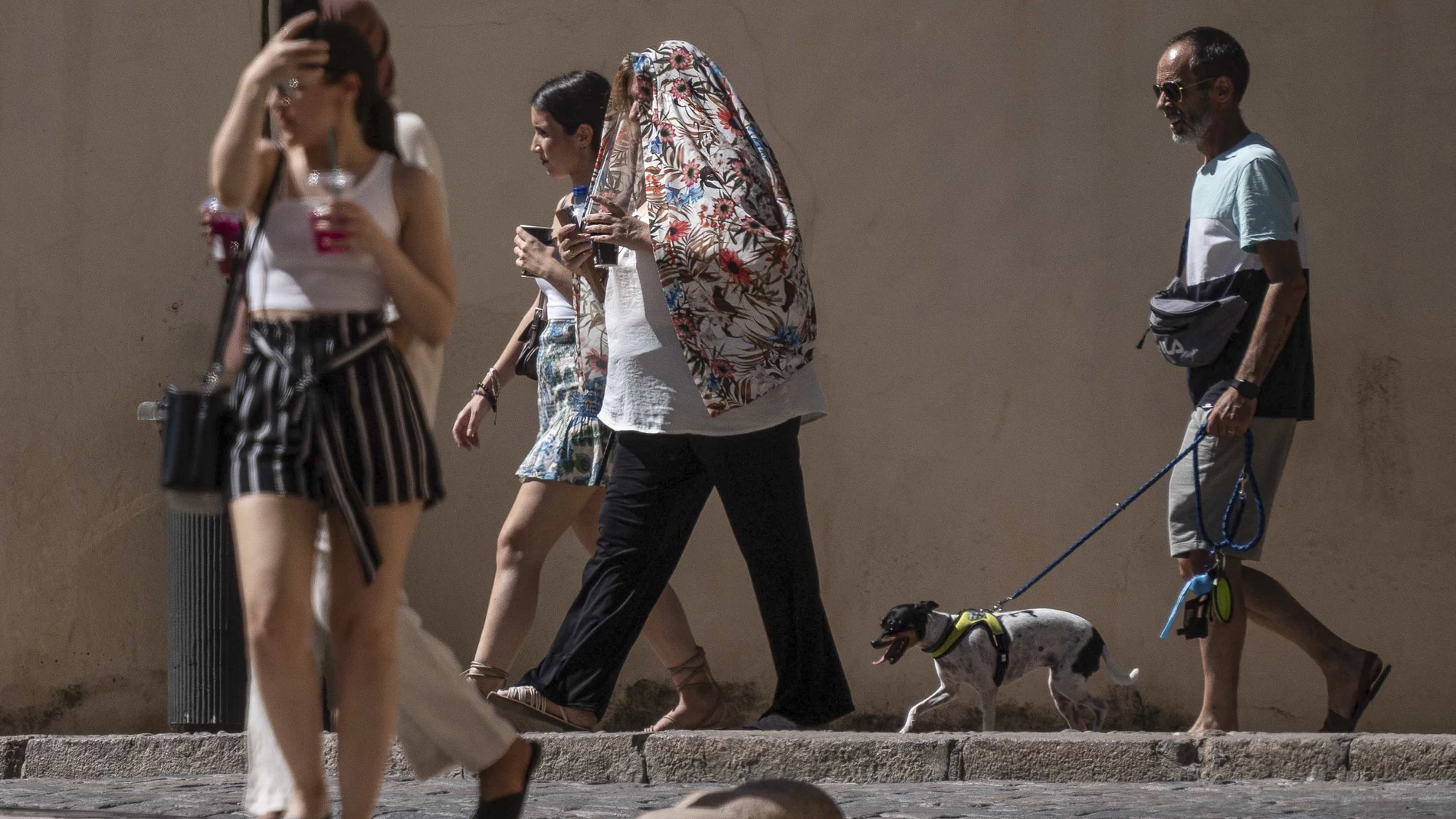 Paseantes se protegen del intenso calor en Córdoba