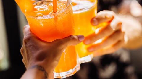Dos amigos brindan con bebidas azucaradas