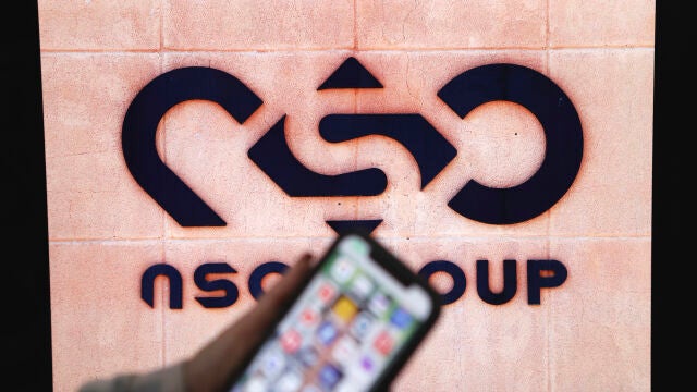 Una ilustración fotográfica muestra un teléfono móvil cerca del logotipo de la empresa NSO Group el 9 de febrero de 2022 en la ciudad israelí de Netanya.