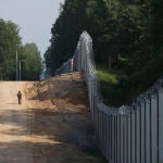 Un guardia fronterizo polaco patrulla la zona de un muro metálico construido en la frontera entre Polonia y Bielorrusia, cerca de Kuznice, Polonia,