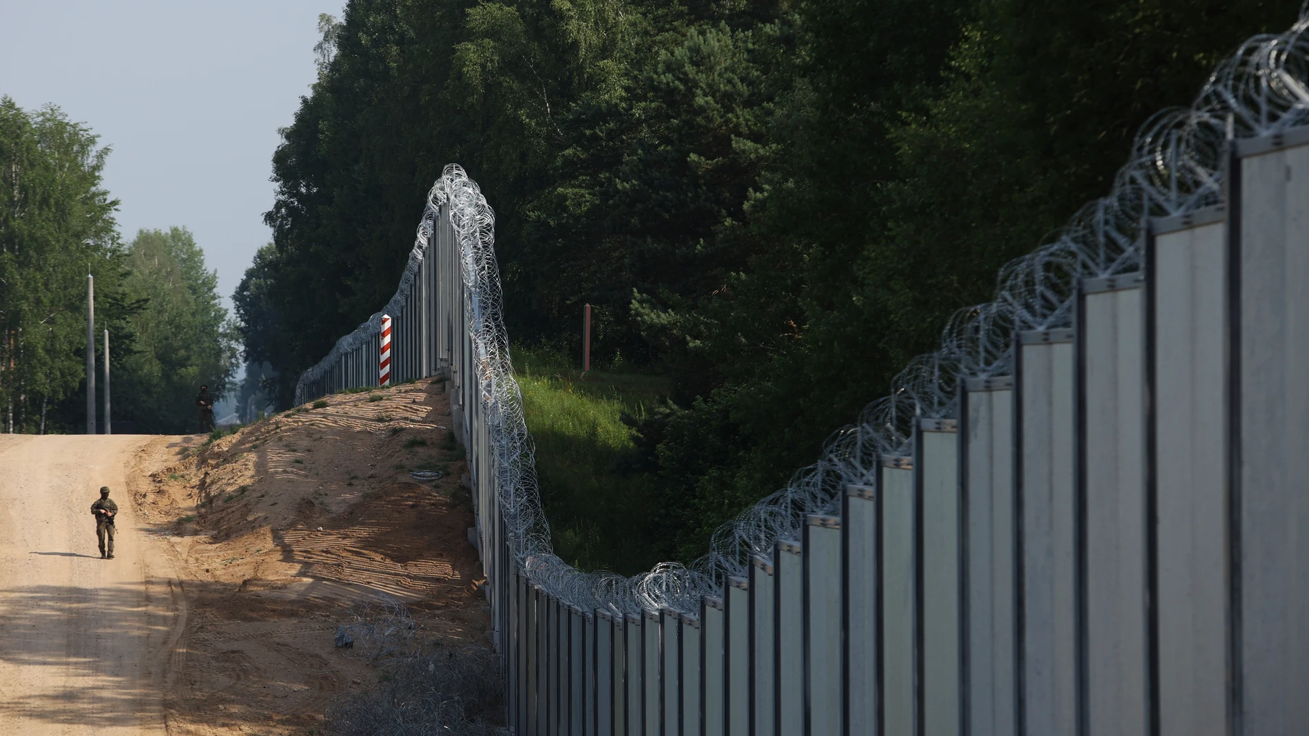 Un guardia fronterizo polaco patrulla la zona de un muro metálico construido en la frontera entre Polonia y Bielorrusia, cerca de Kuznice, Polonia,
