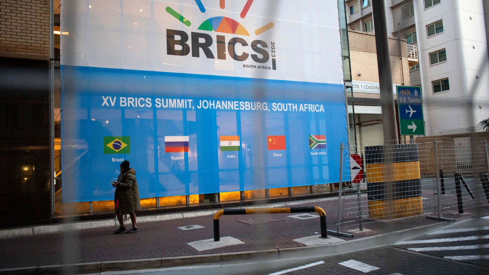 Johannesburg (South Africa), 21/08/2023.- A man walks past a banner as final preparations are underway for the 15th BRICS Summit at the Sandton Convention Centre, Johannesburg, South Africa, 21 August 2023. The security measures have been extremely high as numerous heads of state will take part in the summit. South Africa is hosting the 15th BRICS Summit, which takes place between 22-24 August, where the emerging economies of Brazil, Russia, India and South Africa, and China will attend. The ...