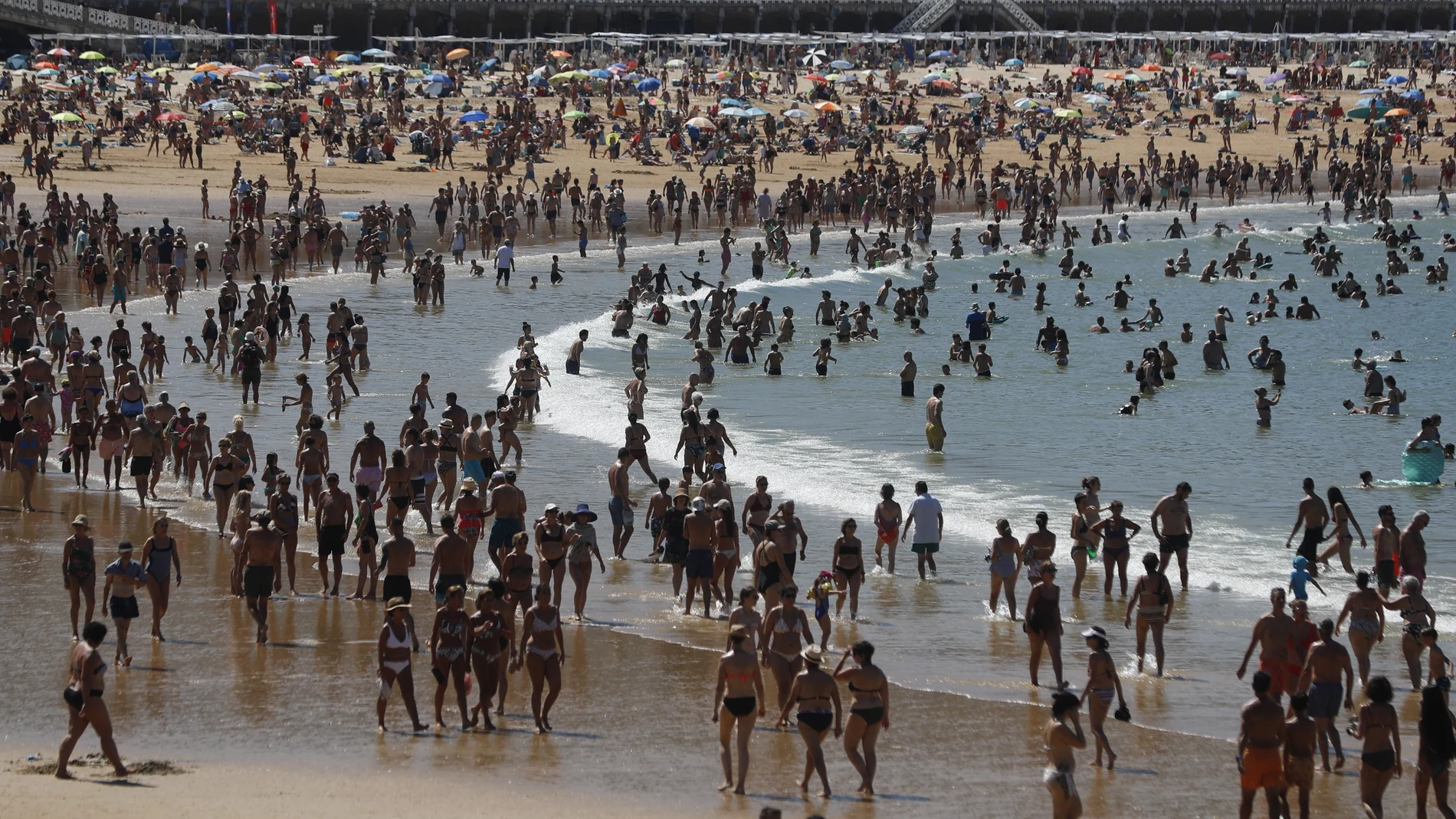Donostiarras y visitantes disfrutan de un día soleado en la playa de la Concha de San Sebastián.