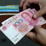 A woman holds Chinese Yuan banknotes. 