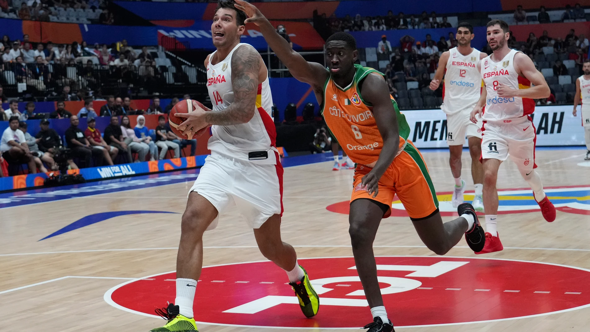 Spain center Willy Hernangomez (14) drives past Cote d'Ivoire forward Mike Fofana (8) during the Basketball World Cup group G match between Spain and Cote d'Ivoire at the Indonesia Arena stadium in Jakarta, Indonesia, Saturday, Aug. 26, 2023. (AP Photo/Achmad Ibrahim)