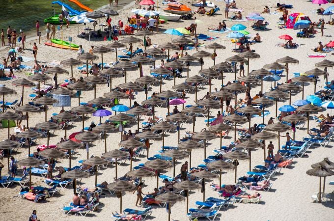 Sombrillas para protegerse del sol en la playa de Cala en Porter, Menorca.