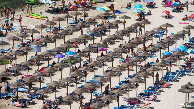 Sombrillas para protegerse del sol en la playa de Cala en Porter, Menorca.