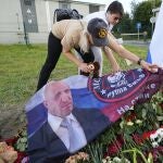 Women place a flag with an image of the owner of private military company Wagner Group Yevgeny Prigozhin at an informal memorial next to the former 'PMC Wagner Centre' in St. Petersburg, Russia.