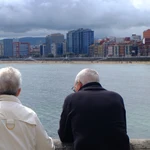 Pensionistas : mayores miran el mar en el paseo marítimo de Gijón