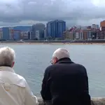 Pensionistas : mayores miran el mar en el paseo marítimo de Gijón