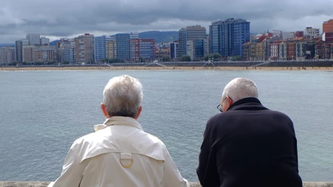 Pensionistas : mayores miran el mar en el paseo marítimo de Gijón