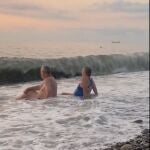 Pareja de abuelitos juegan con las olas del mar