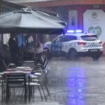 Varias personas se protegen de la lluvia en una terraza este sábado en Huesca (Aragón)