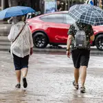 Dos personas caminan en Madrid bajo la lluvia