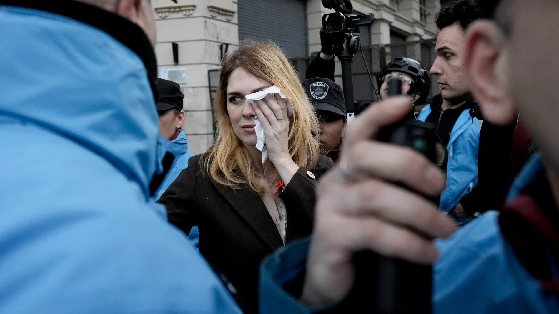 LIlia Lemoine, a candidate for Argentina's lower house of Congress for the Liberty Advances party led by Javier Milei, covers her eye after an alleged attack by protesters outside the Buenos Aires City Legislature in Buenos Aires, Argentina, Monday, Sept. 4, 2023. Demonstrators protested an event organized by Milei's running mate Victoria Villarruel to honor victims of armed 1970's leftist groups. (AP Photo/Rodrigo Abd)