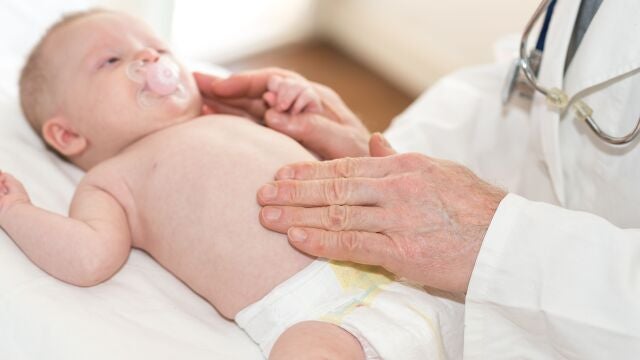 Médico pediatra examinando a un bebé