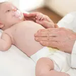 Médico pediatra examinando a un bebé