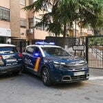 Un reportero graba imágenes de los patrulleros de la Policía Nacional en la entrada de la vivienda de la mujer localizada este domingo en Granada muerta con signos de violencia después del suicidio de un hombre, quién se arrojó desde un balcón en esa misma calle, falleciendo en el acto. 
