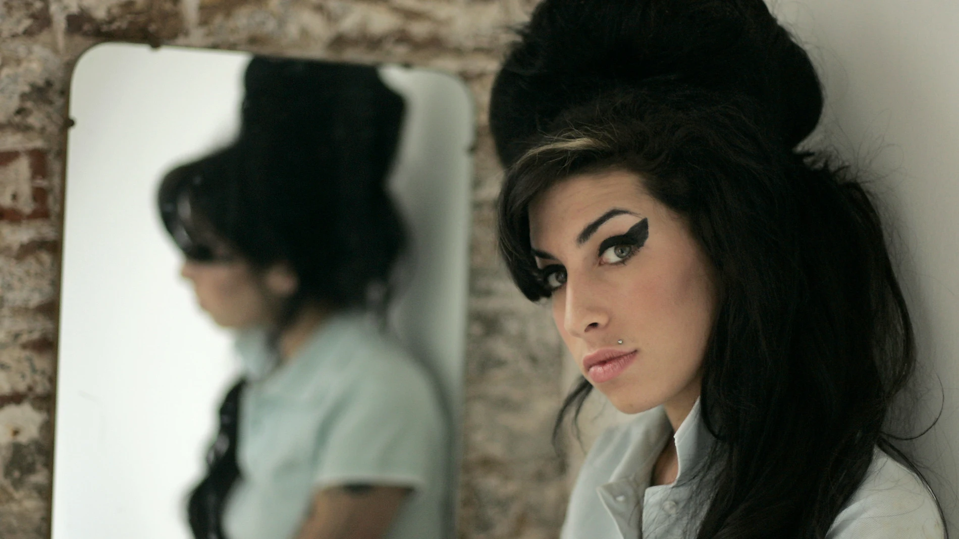 In this Feb. 16, 2007 file photo, British singer Amy Winehouse poses for photographs after being interviewed by The Associated Press at a studio in north London.