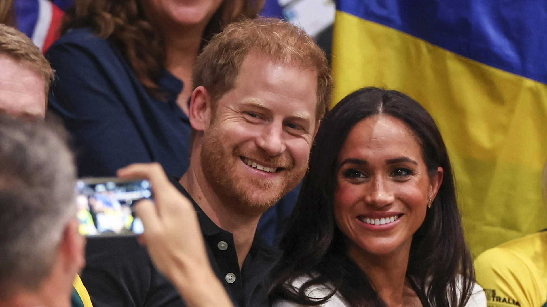 Britain's Prince Harry (C), Duke of Sussex, and his wife Meghan, Duchess of Sussex smile for a picture during a Wheelchair Basketball game at the 6th Invictus Games in Duesseldorf, Germany,