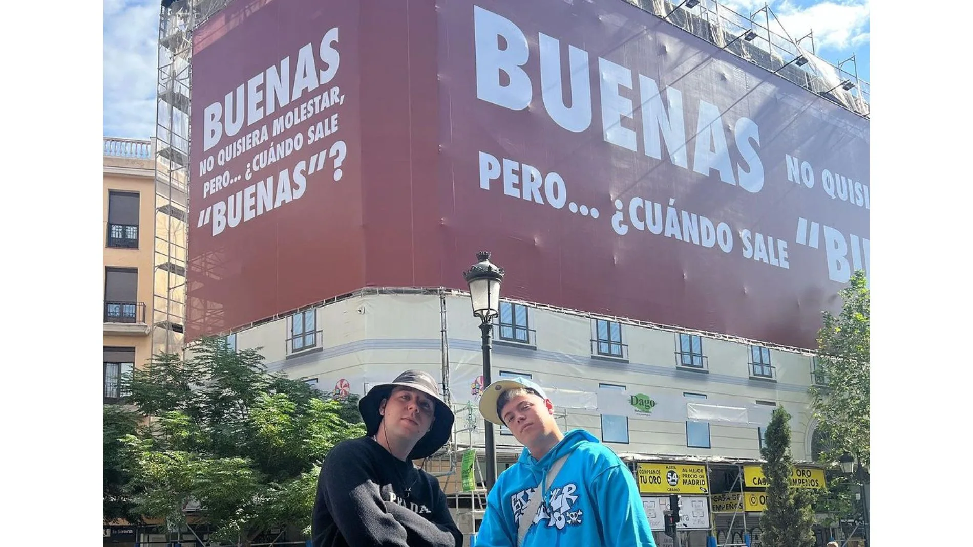 Quevedo y Saiko posan con el cartel promocional de su nueva canción 'Buenas'