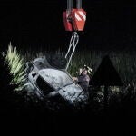 Rescatistas retiran los restos de un coche en el lugar donde se estrelló un avión cerca del aeropuerto de Caselle