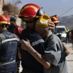 A man hugs a member of the civil protection team as they prepare to recover bodies of victims from a collapsed building, Imi Ntala, Amizmiz, south of Marrakesh, Morocco