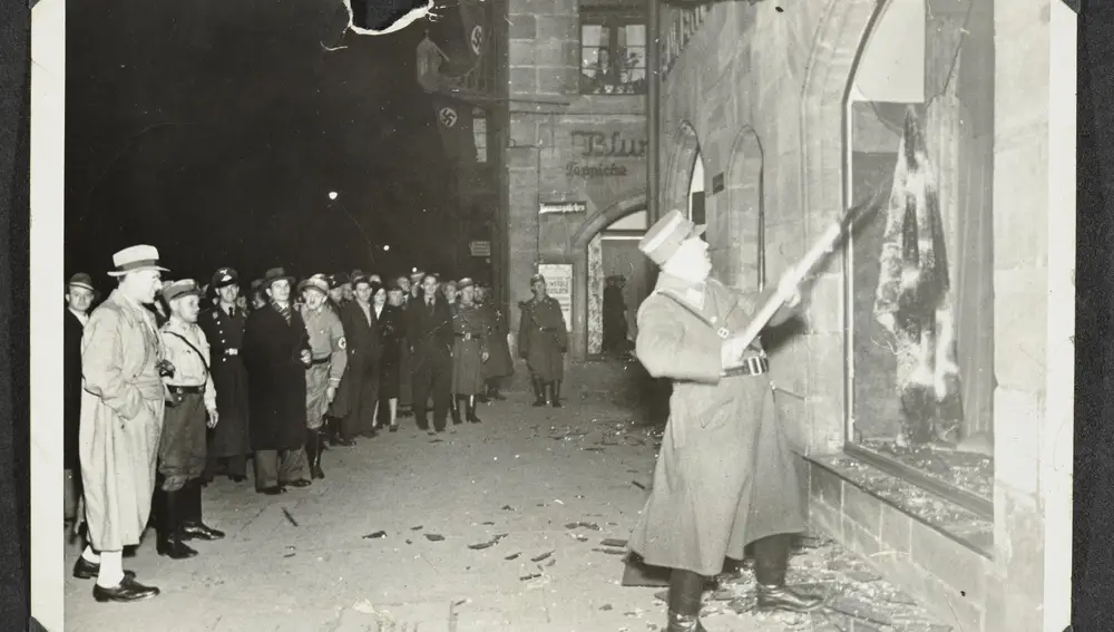 This photo released by Yad Vashem, World Holocaust Remembrance Center, shows German Nazis and civilians watch ransacking of Jewish property during Kristallnacht intake most likely in the town of Fuerth, Germany on Nov. 10, 1938