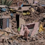 Una mujer intenta recuperar algunas de sus pertenencias de su casa dañada por el terremoto en el pueblo de Tafeghaghte, cerca de Marrakech