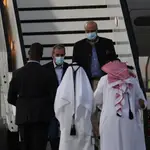 Los estadounidenses Emad Sharqi (dcha., detrás) y Morad Tahbaz (cda., detrás), que se encuentran entre los cinco presos liberados por Irán, desembarcan de un avión al aterrizar en Doha (Qatar)