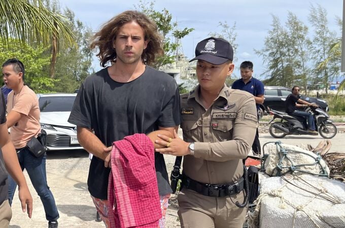 A Thai police officer escorts Spanish Daniel Sancho Bronchalo on suspicion of murdering and dismembering a Colombian surgeon from Koh Phagnan island to Koh Samui Island court, southern Thailand, Monday, Aug. 7, 2023. Sancho, the son of two Spanish film stars, has been arrested in Thailand on suspicion of murdering and dismembering Edwin Arrieta Arteaga on a tourist island, police said. Sancho was taken from Koh Phagnan, where the remains of the Colombian surgeon were found, to another island, Samui, where he is being held, Surat Thani provincial police commander Saranyu Chamnanrat said Tuesday. (AP Photo/Somkeat Ruksaman)